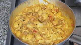 Orecchiette con salsiccia e crema di burrata e pomodorini.